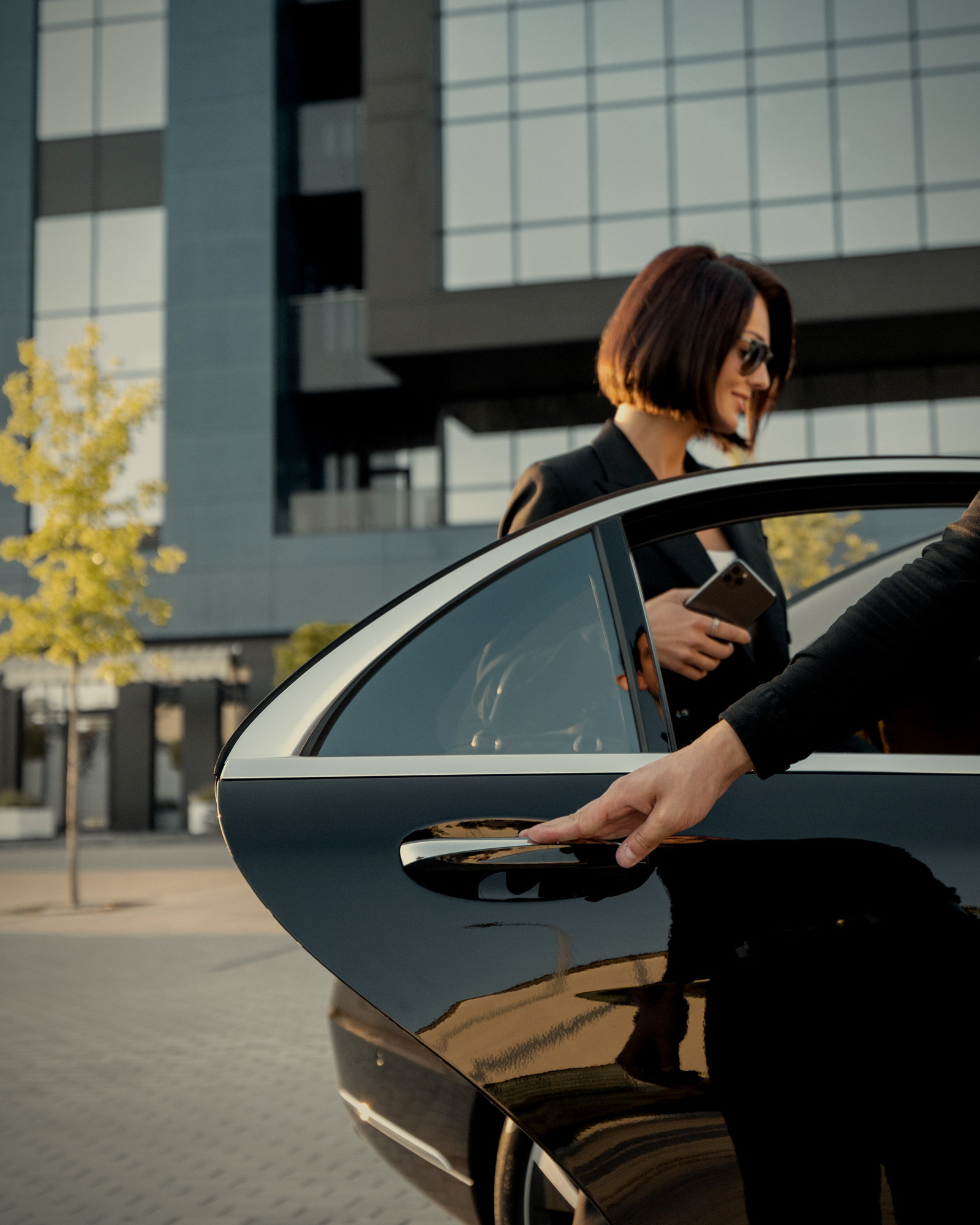 Chauffeur ALLO VTC 77 ouvrant la portière à une cliente en ville